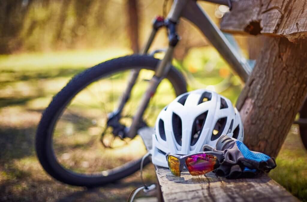 Bicycle gear, helmet, gloves on the bench on a sunny day. Bicycle gear, helmet, gloves on the bench on a sunny day.
