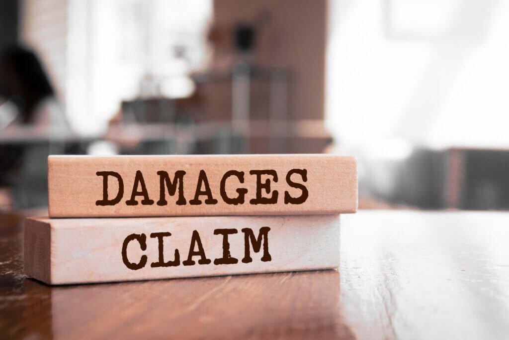 Wooden blocks with the words Damages and Claim Wooden blocks with the words Damages and Claim